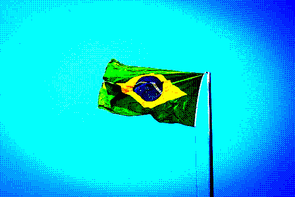 Flag of the Federative Republic of Brazil on a flagpole, flying in the wind with a blue sky