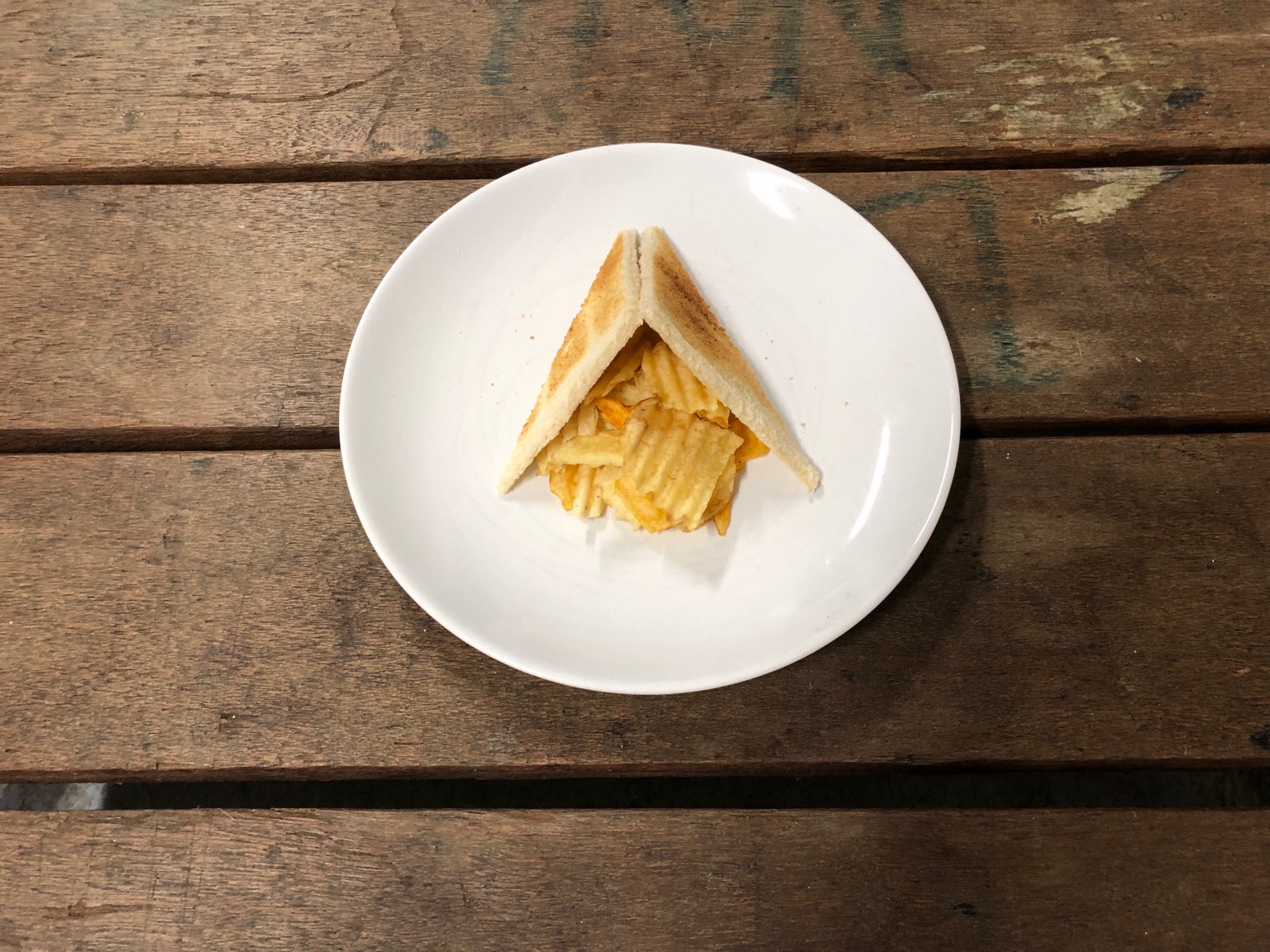 Diagonally-cut toast leaning above crisps