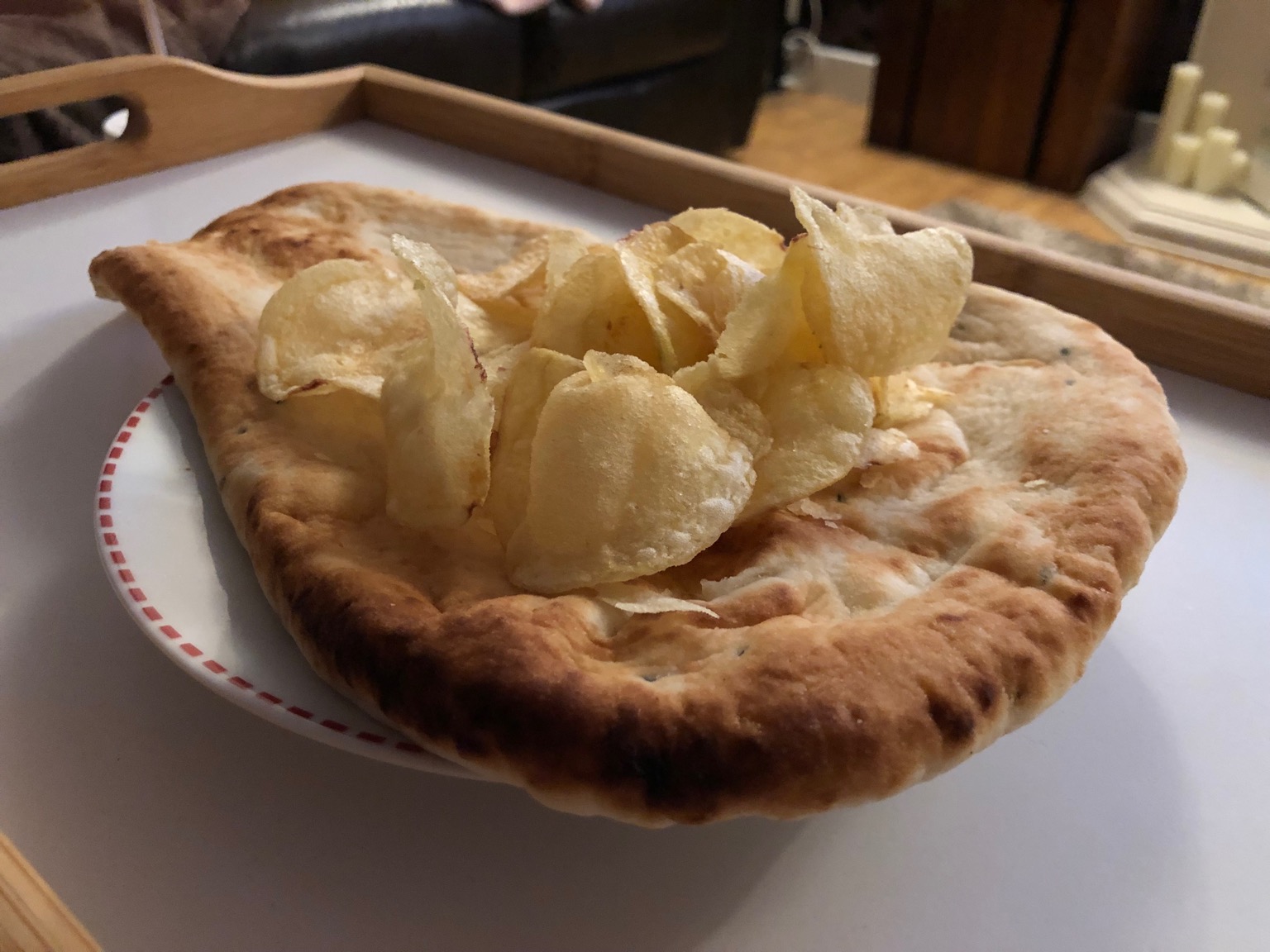 Potato crisps laid on a whole naan bread