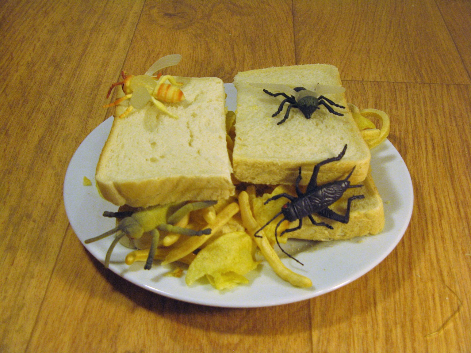 Halved sandwich covered with plastic insects