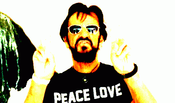 Ringo doing his peace and love peace signs figures thing while wearing a t-shirt saying Peace Love