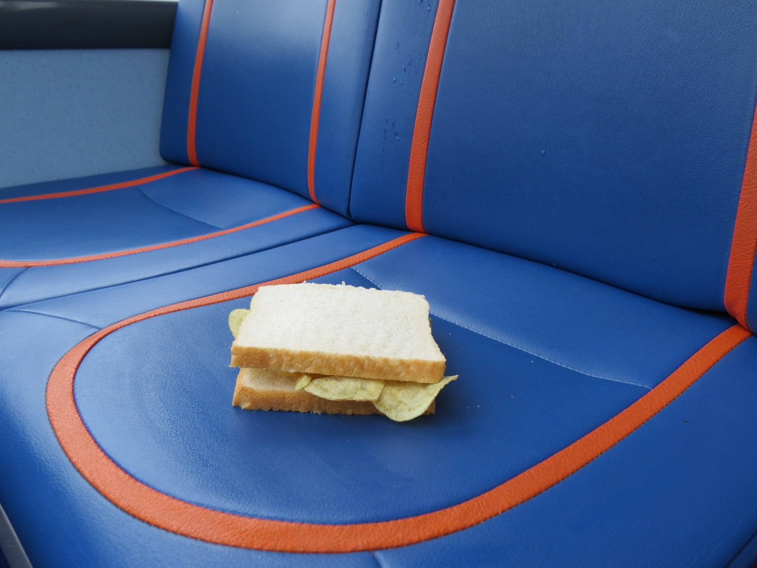 Close up of crisp sandwich placed on a bus seat