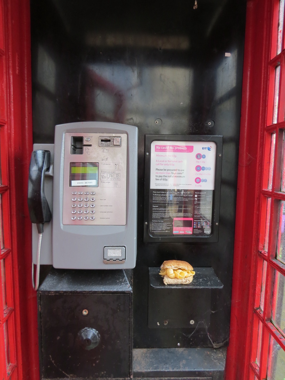 Red phone box containing a brown Quavers roll