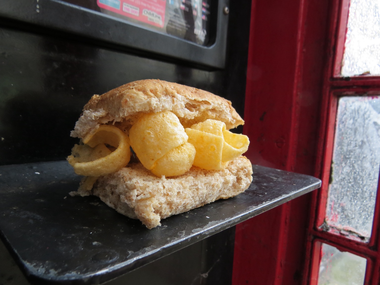 Close up of brown Quavers roll in a red phone box