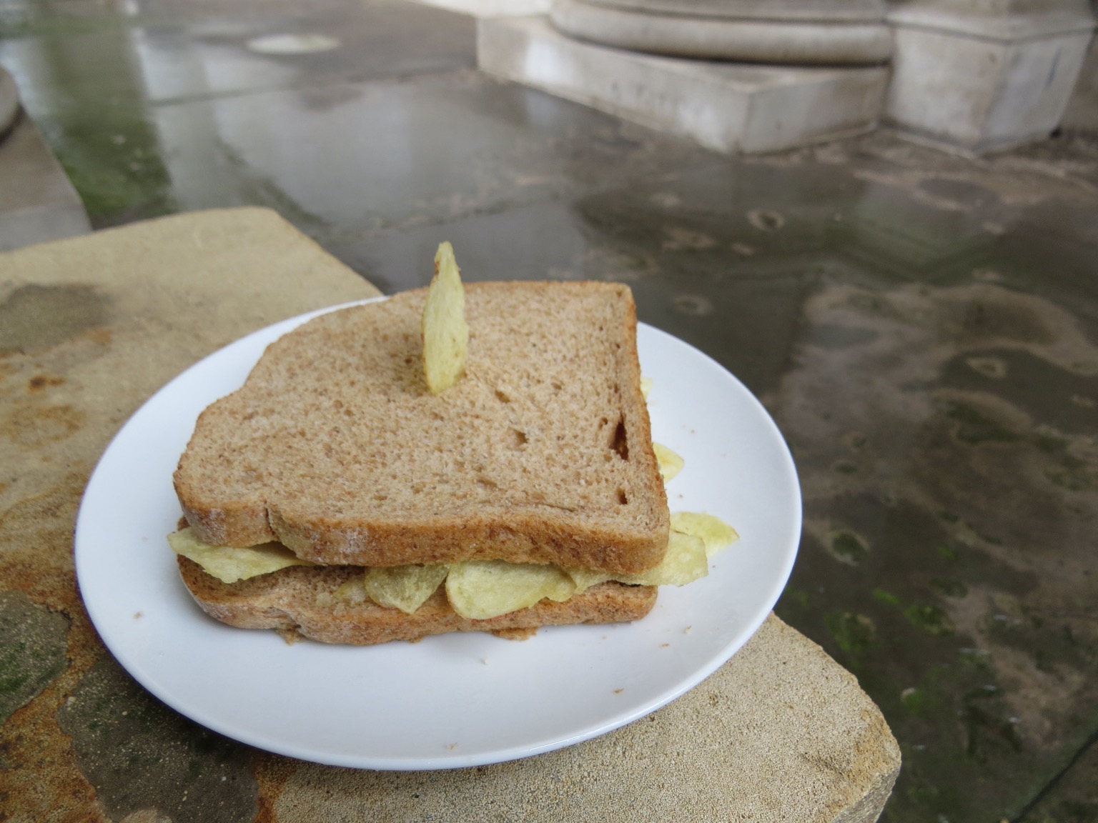 Crisp sandwich with crisp stuck in it on a plate