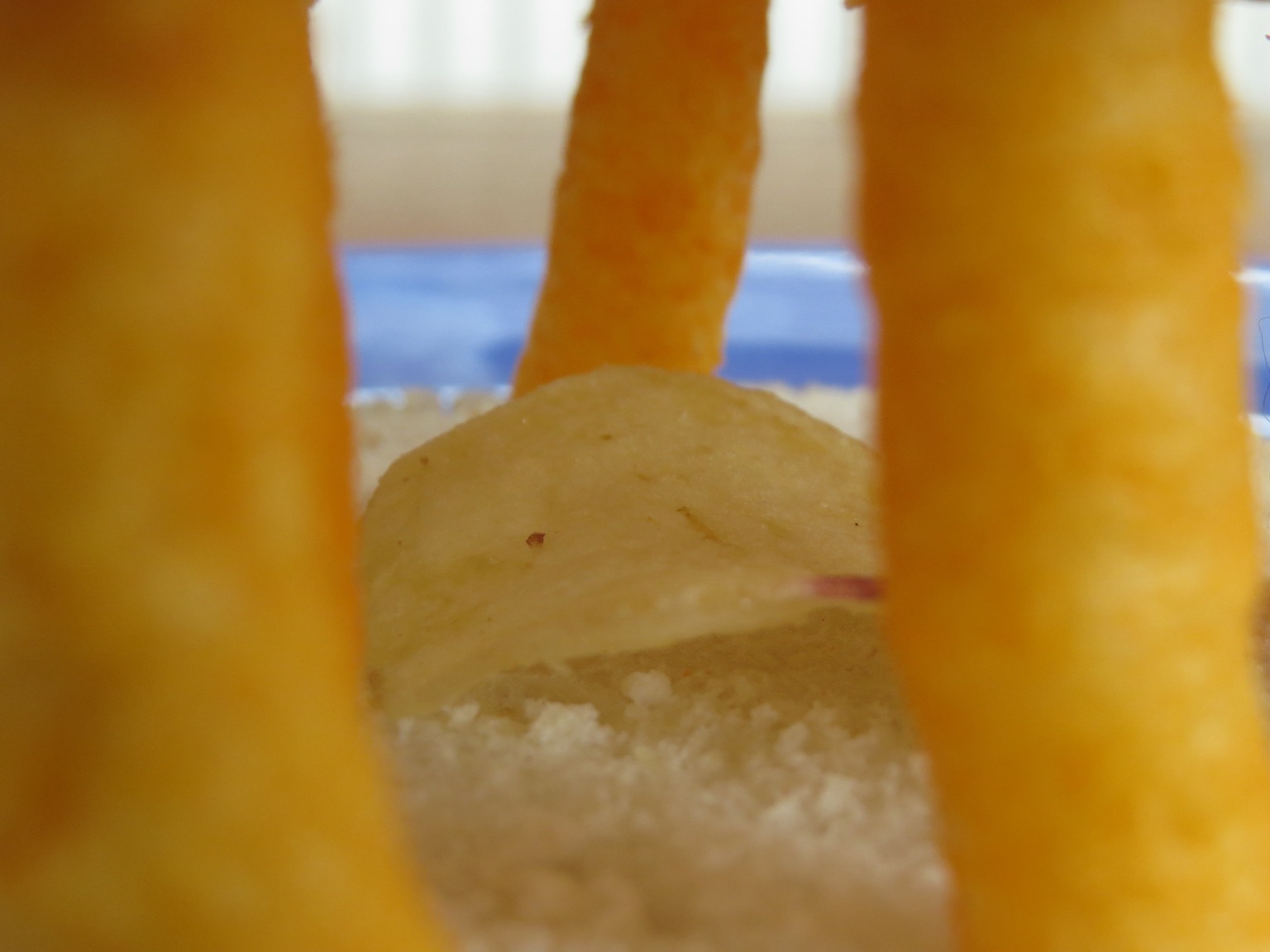 Close up of potato crisp among Wotsits and bread