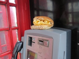 Brown Quavers roll on top of phone unit in a phone box