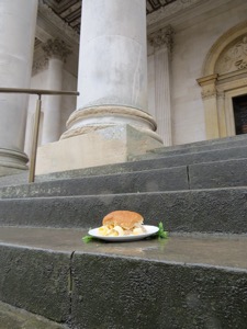 Brown Quavers roll on wet steps in front of a column