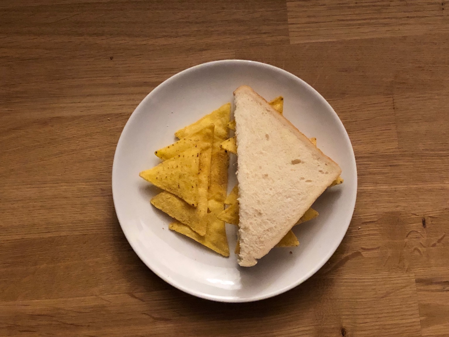 Doritos in and alongside diagonally-cut white bread 