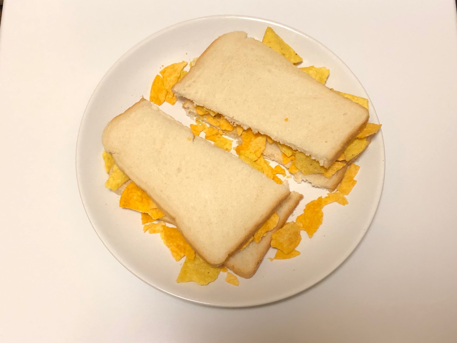 Doritos within and around white sliced bread