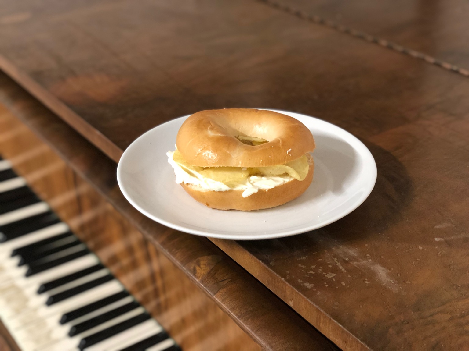 Crisps and cream cheese in a bagel on a piano