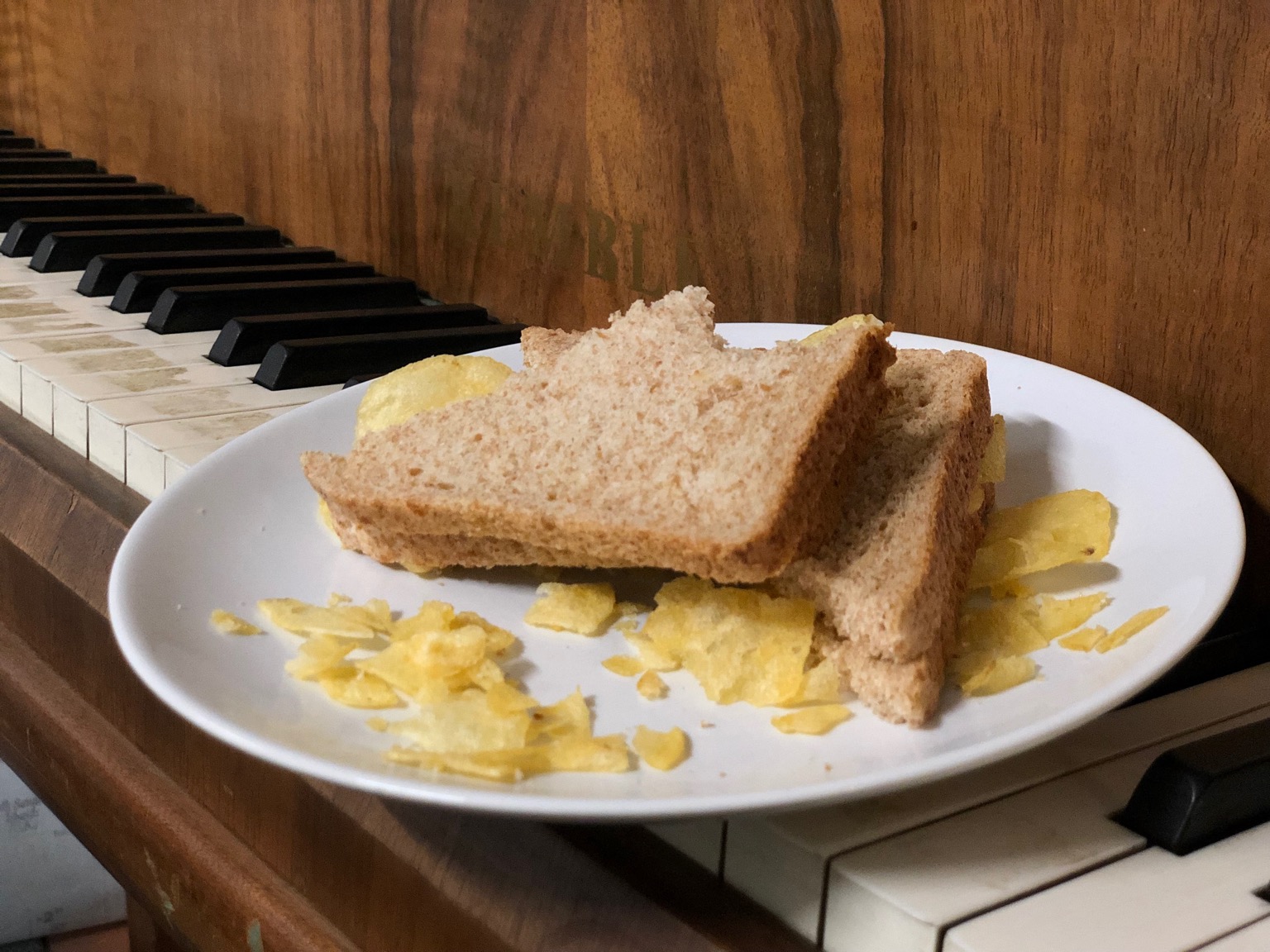 Bitten brown bread crisp sandwich on a piano