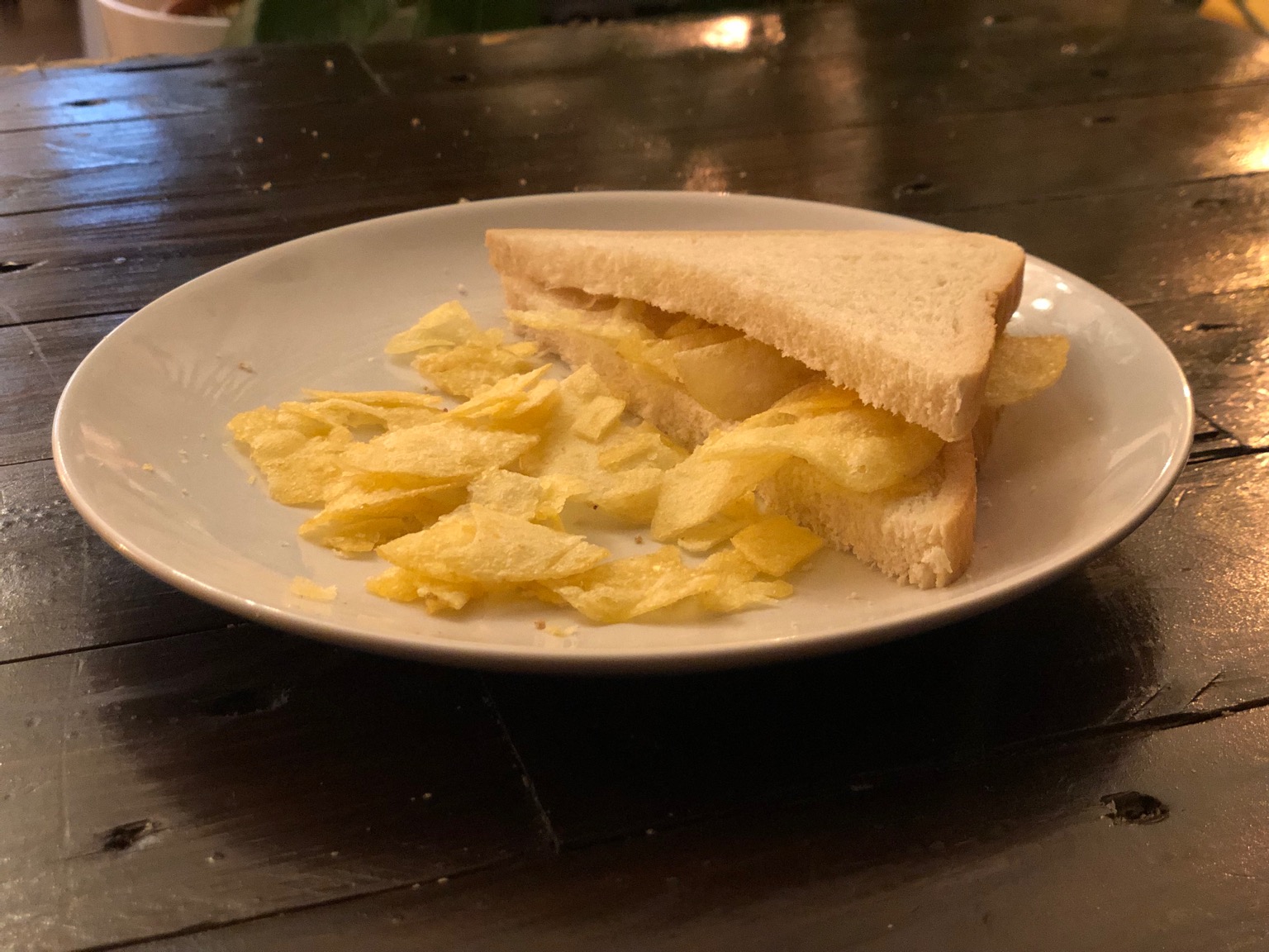 Potato crisps in and alongside white sliced bread