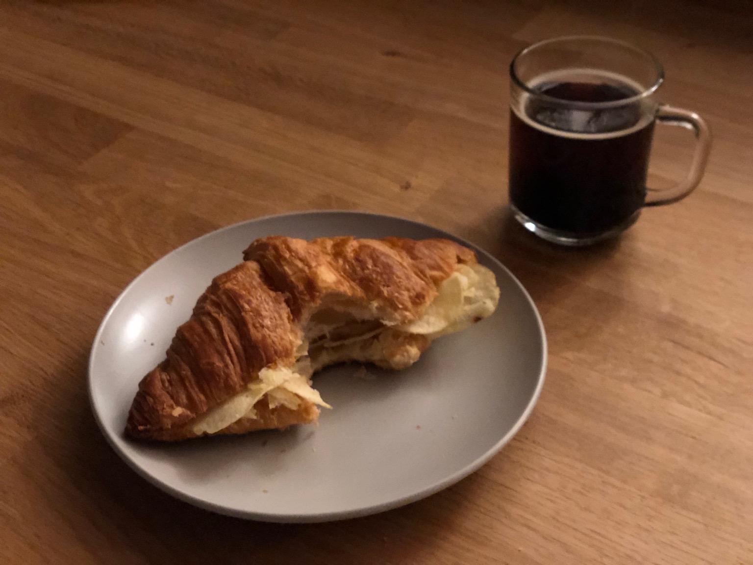 Crisp croissant with bite taken alongside drink