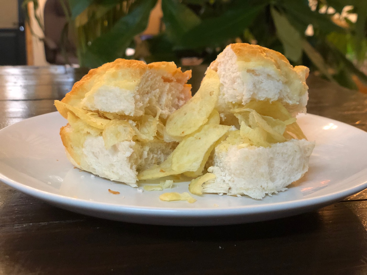Crisps in and around a halved cheese-topped roll
