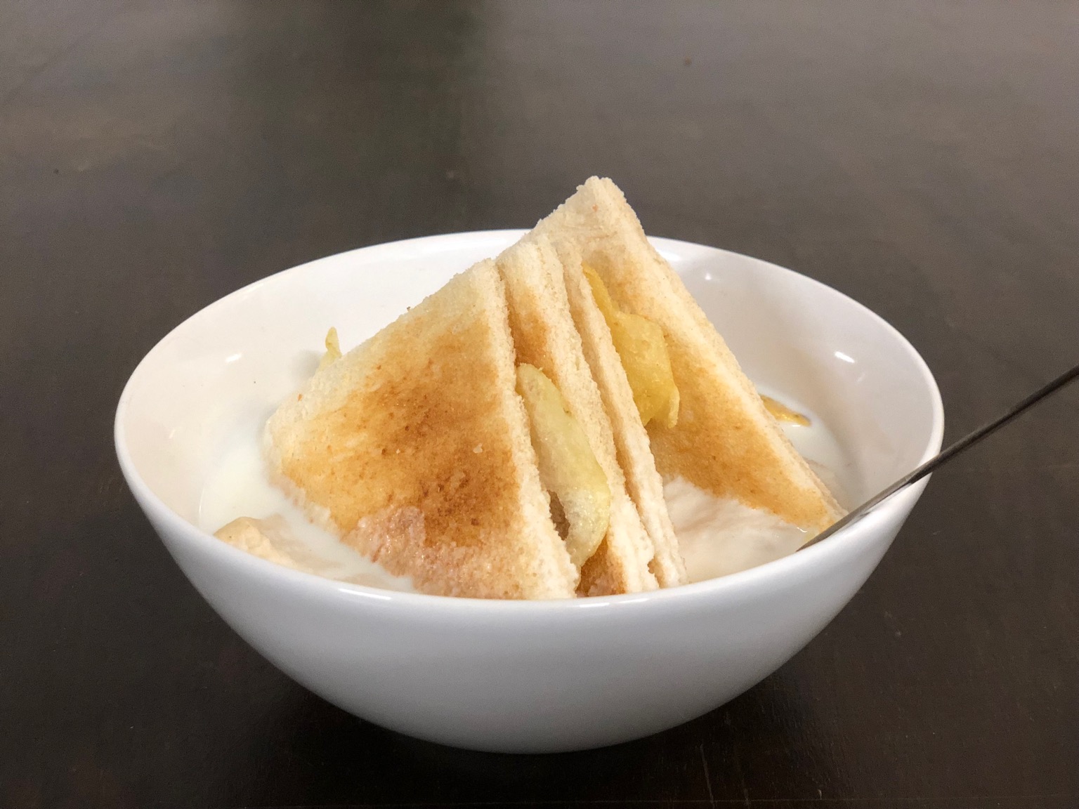 Crustless toasted crisp sandwich in a bowl of milk