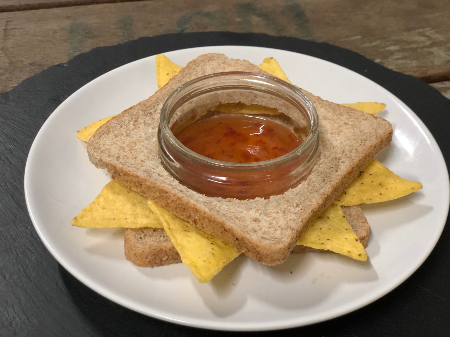 Doritos in brown bread with hole for jar of dip