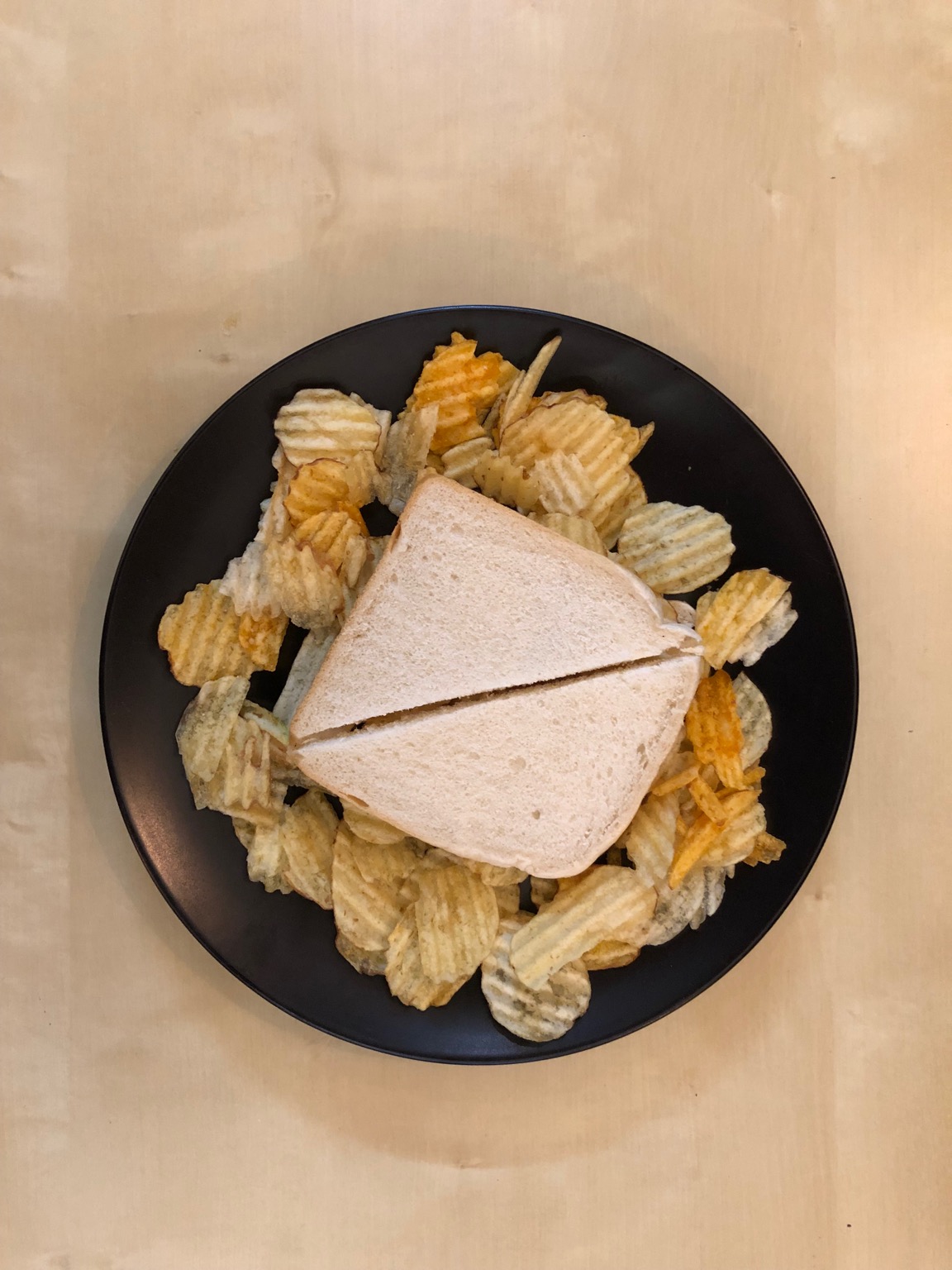 Overhead view of crisps surrounding a sandwich