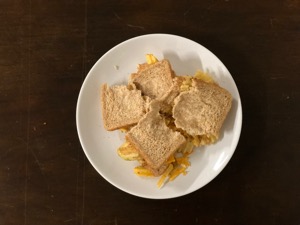 Crinkle-cut crisps in torn sliced brown bread