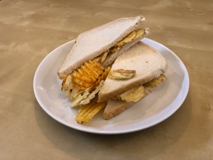 Crinkle-cut crisps spilling out of white sliced bread