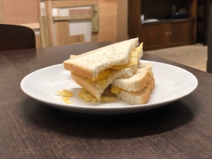 Potato crisps in sliced white bread with bite taken