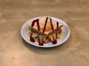 Crinkle-cut crisps in white toast with drizzle