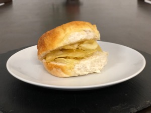 Crisps in a white roll with cheese melted onto it