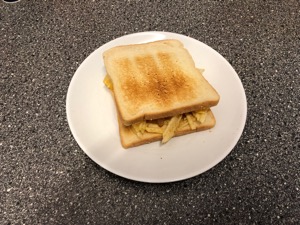 Crinkle-cut crisps between slices of white toast