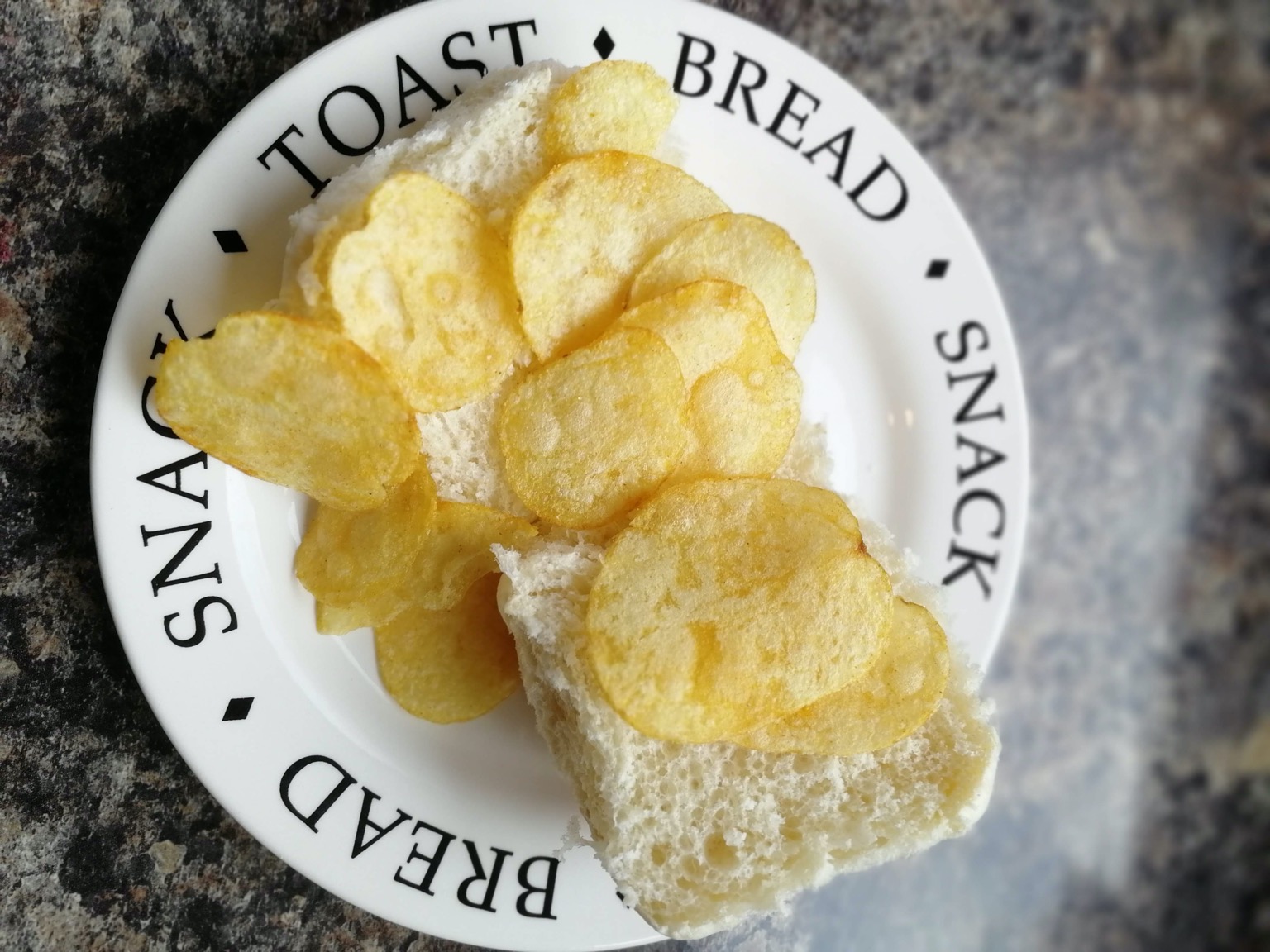 Overhead view of crisps on an open white roll