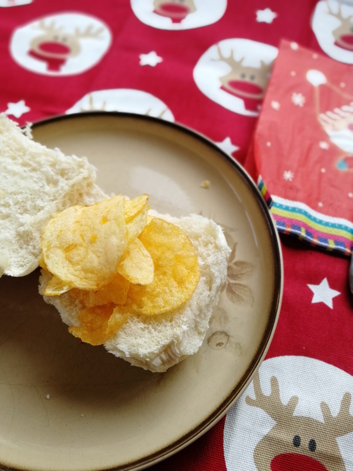 Crisps on an open white roll, festive setting