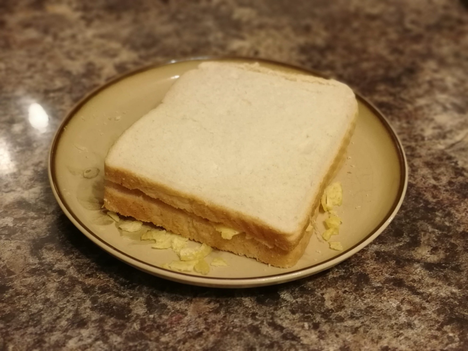 Crisp sandwich on a plate on a granite surface