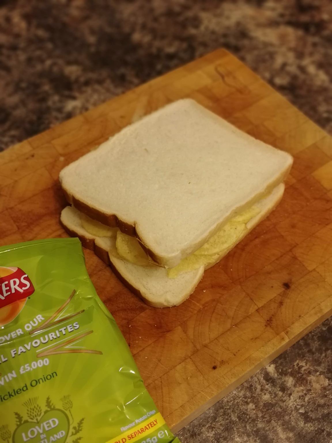 White crisp sandwich on a chopping board with bag
