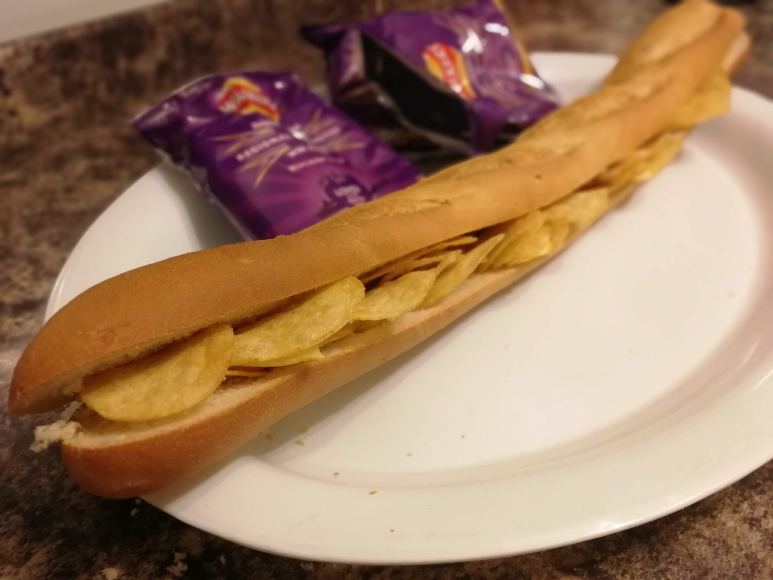 Long crisp-filled baguette alongside empty bags