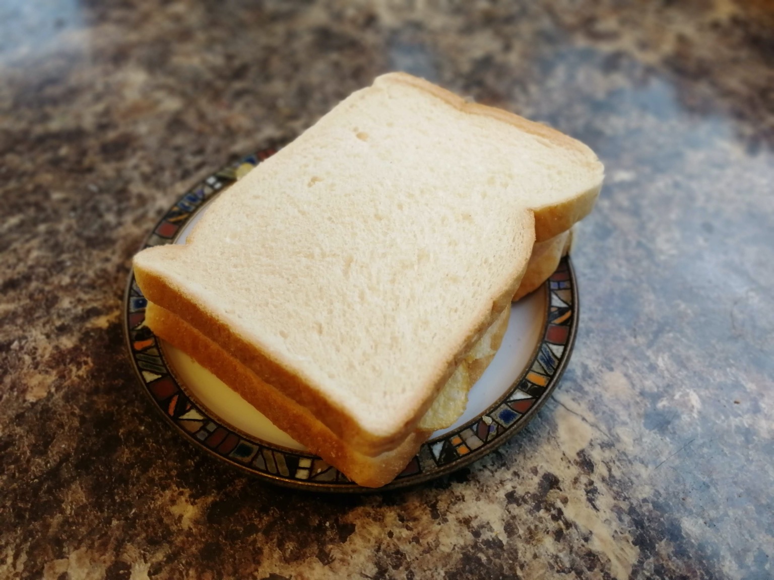 White crisp sandwich on a small plate on granite