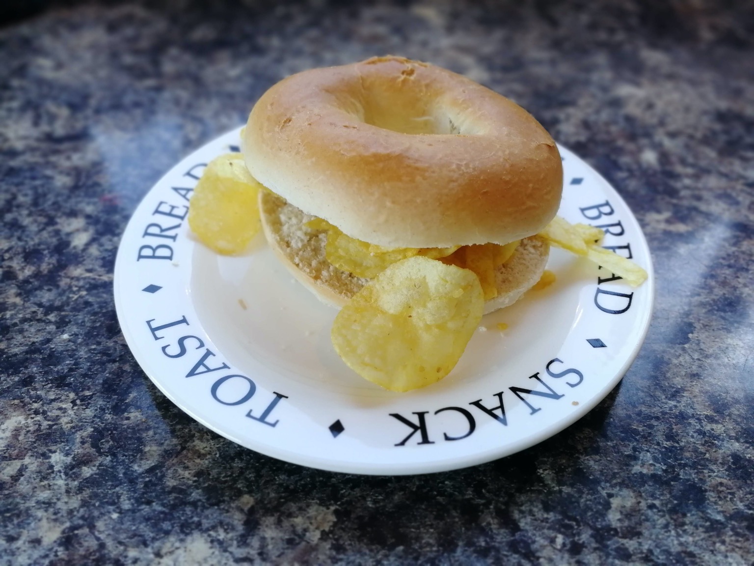 Crisp-overfilled bagel on a typographic plate