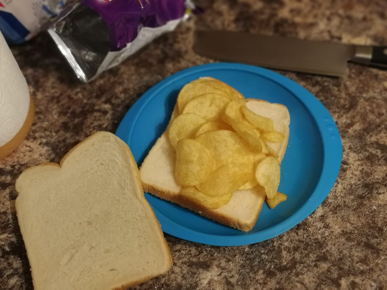 White crisp sandwich on a plastic plate with lid off