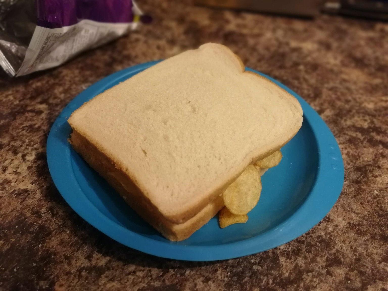 Crisp-filled white sandwich on a plastic plate