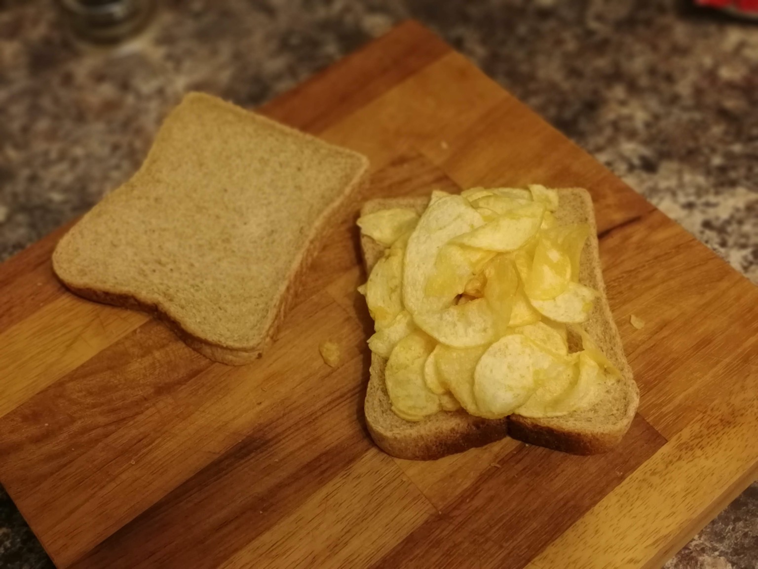 Brown crisp sandwich with lid off on chopping board