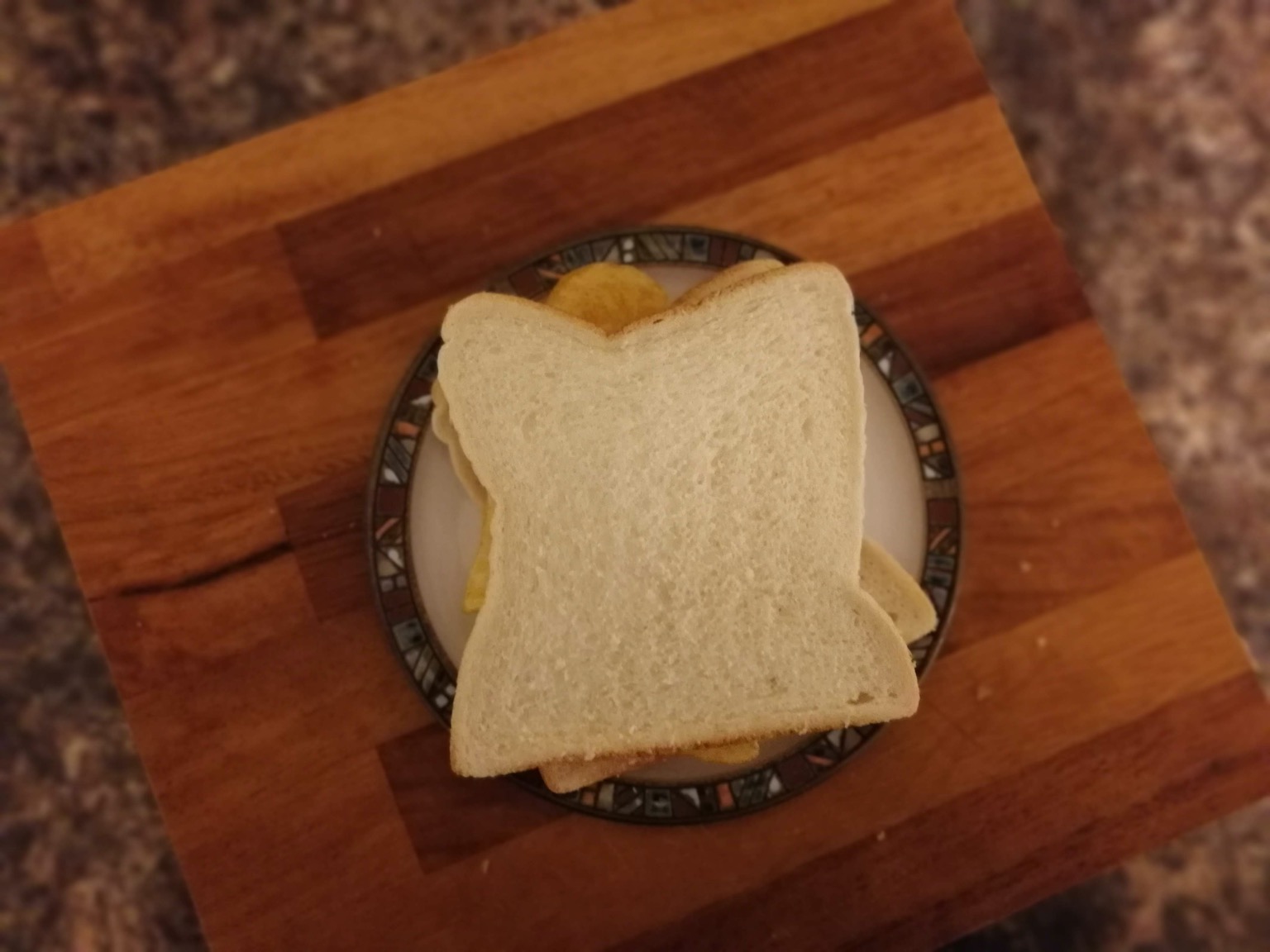 Overhead view of white crisp sandwich on chopping board