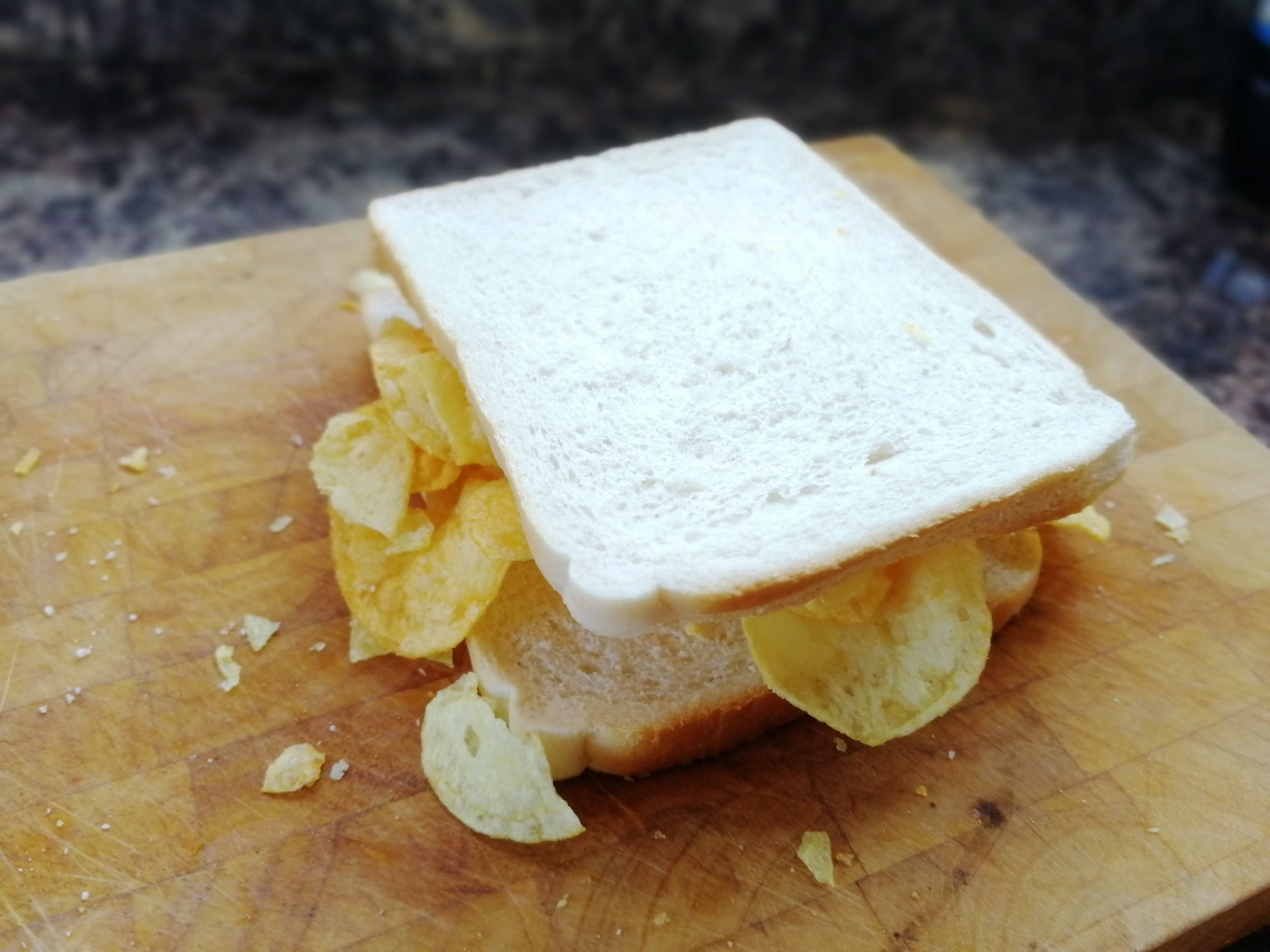 White bread sandwich with crisps falling out