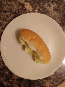 Overhead view of white finger roll containing crisps