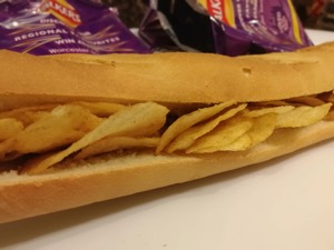 Close up of crisp-filled baguette with empty bags