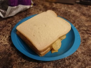 Crisp-filled white sandwich on a plastic plate