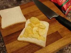 White crisp sandwich with lid off alongside knife