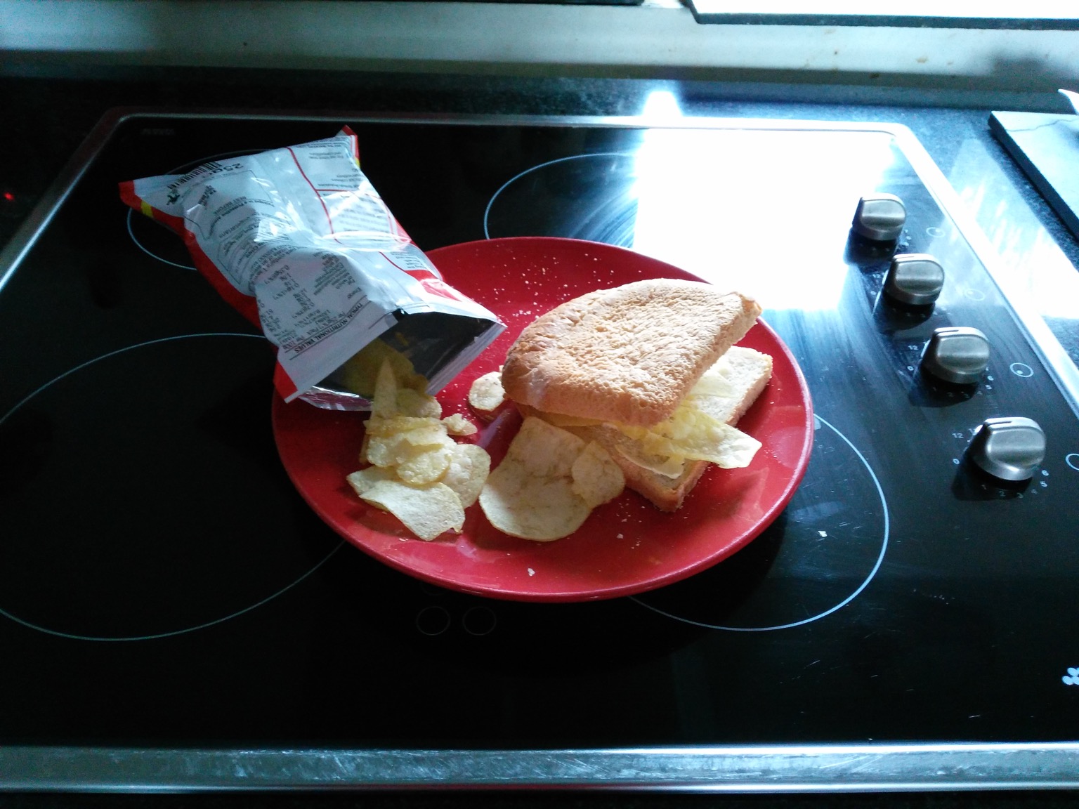 Crisp bag alongside white bread sandwich
