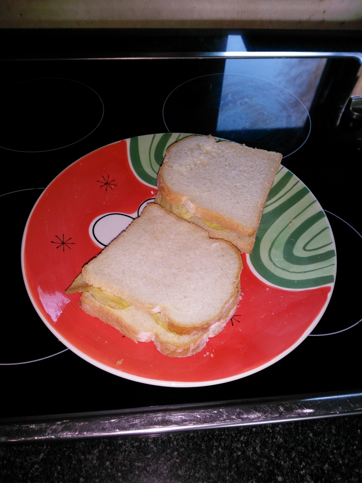 Two sandwiches of sliced white bread with crisps