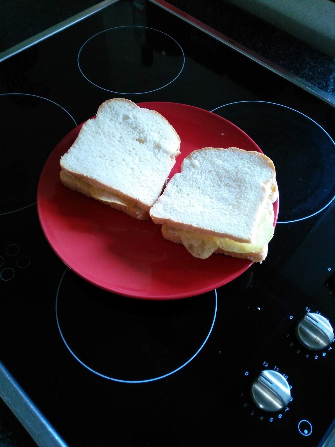 Two sandwiches containing potato crisps