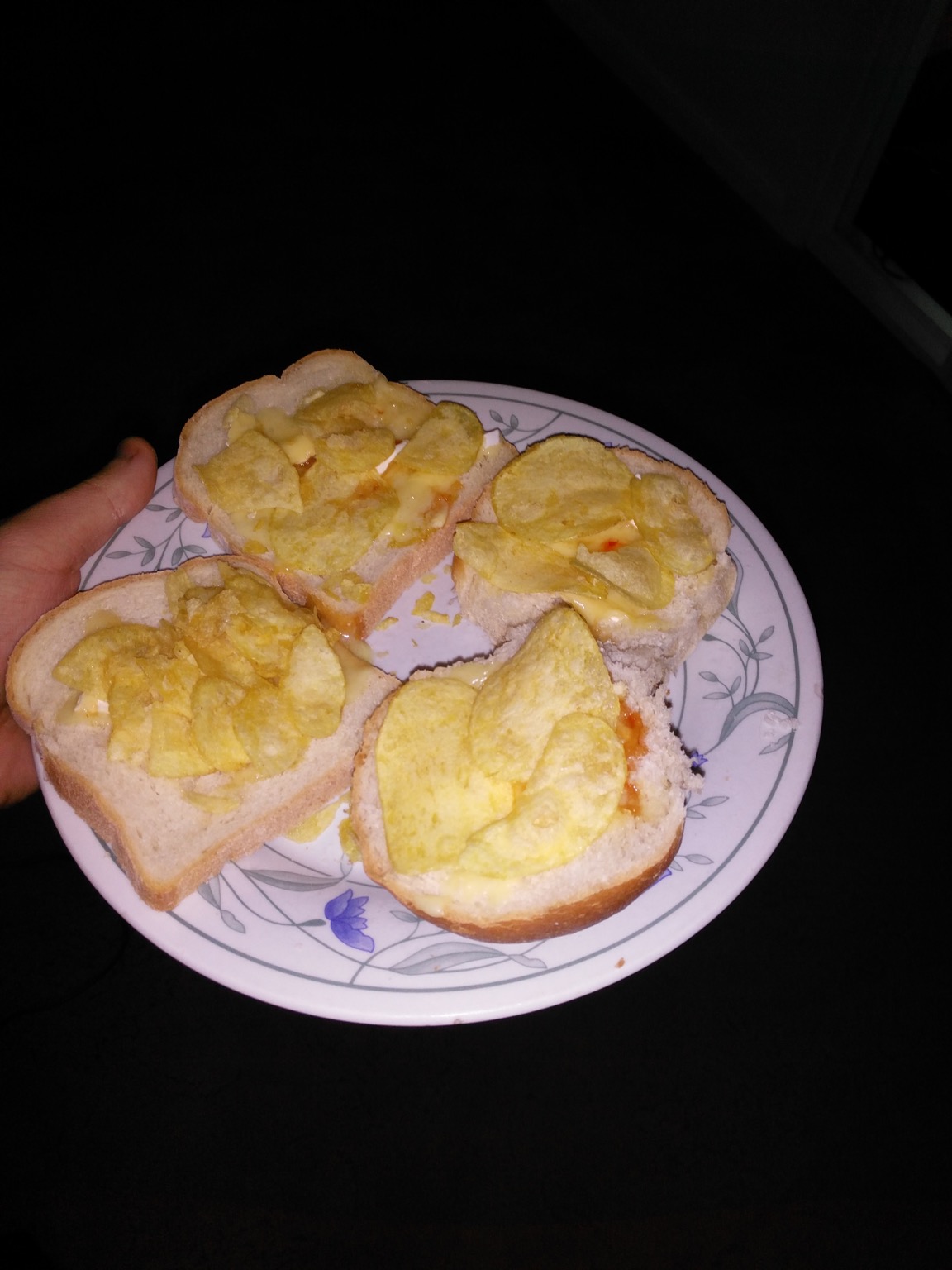 Flash photo of crisps and cheese on bread and roll