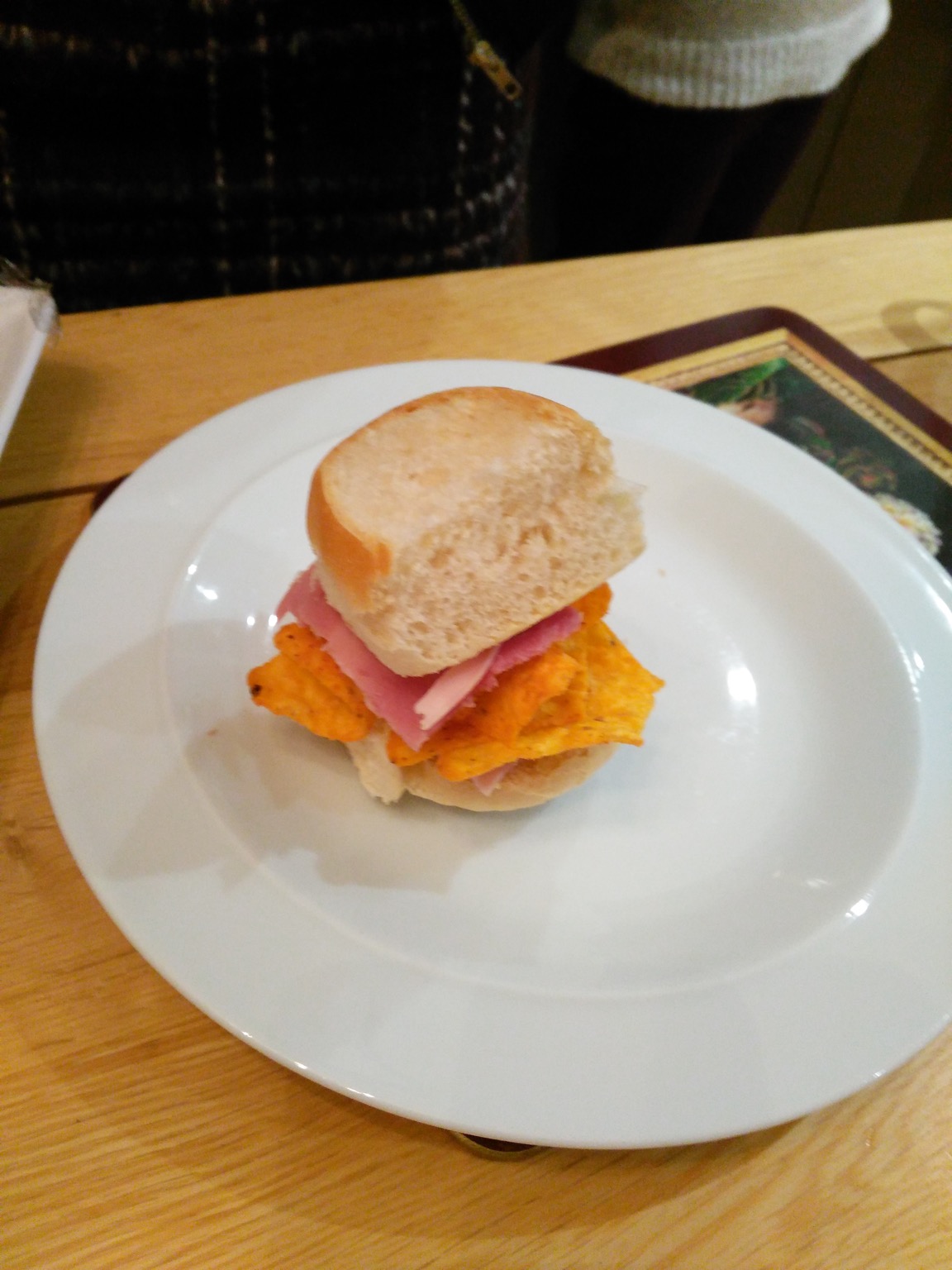 Dainty white roll containing ham and Doritos