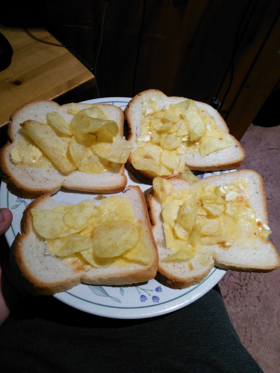 Four slices of white bread with crisps and cheese
